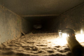 View of the inside of the duct showing the build up of dirt and dust causing materials before it was cleaned